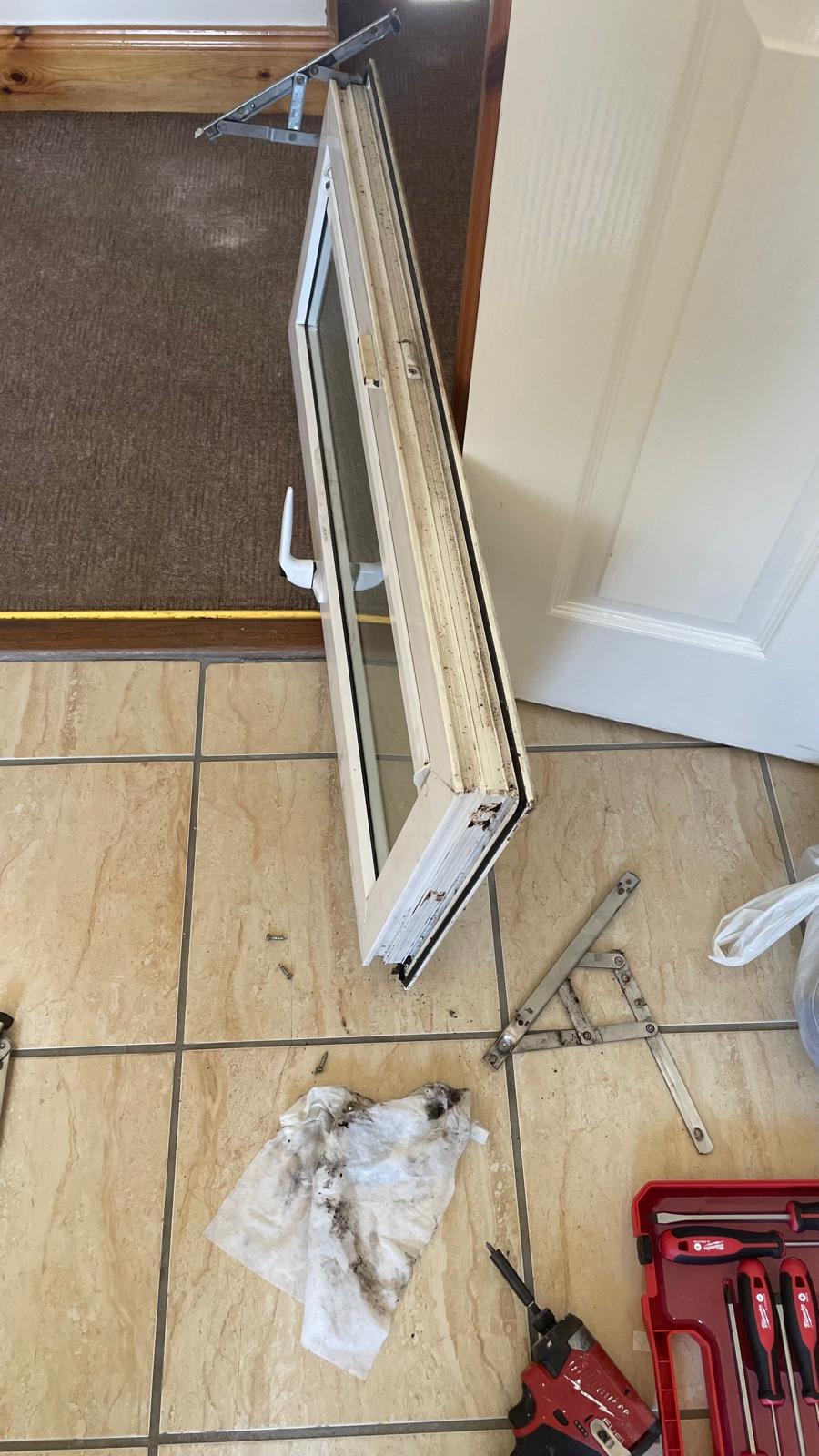 Close-up of a worn window hinge in need of repair